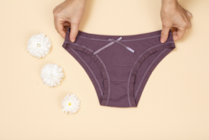 Two hands present purple underwear 